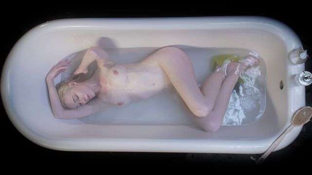 Молодая девушка нежится в теплой ванне и ласкает пилотку